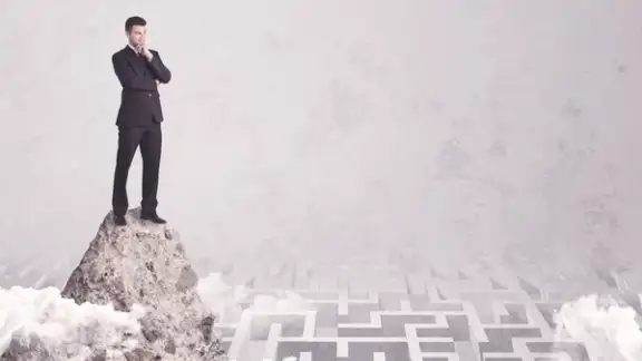 Maze is no challenge for successful businessman standing on top of a cliff as he is the best at solving problems concept.jpeg