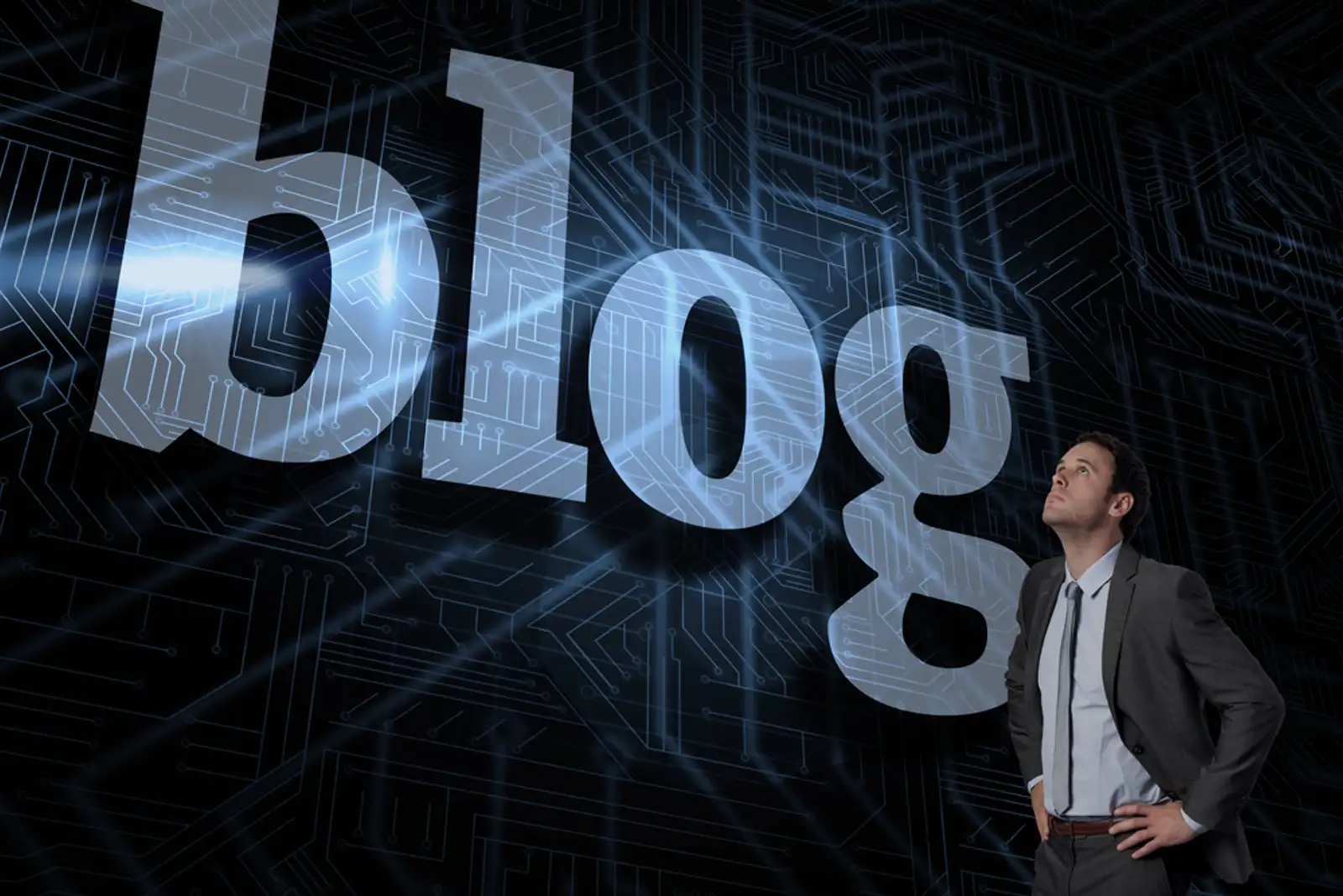 The word blog and serious businessman with hands on hips against futuristic black and blue background.jpeg
