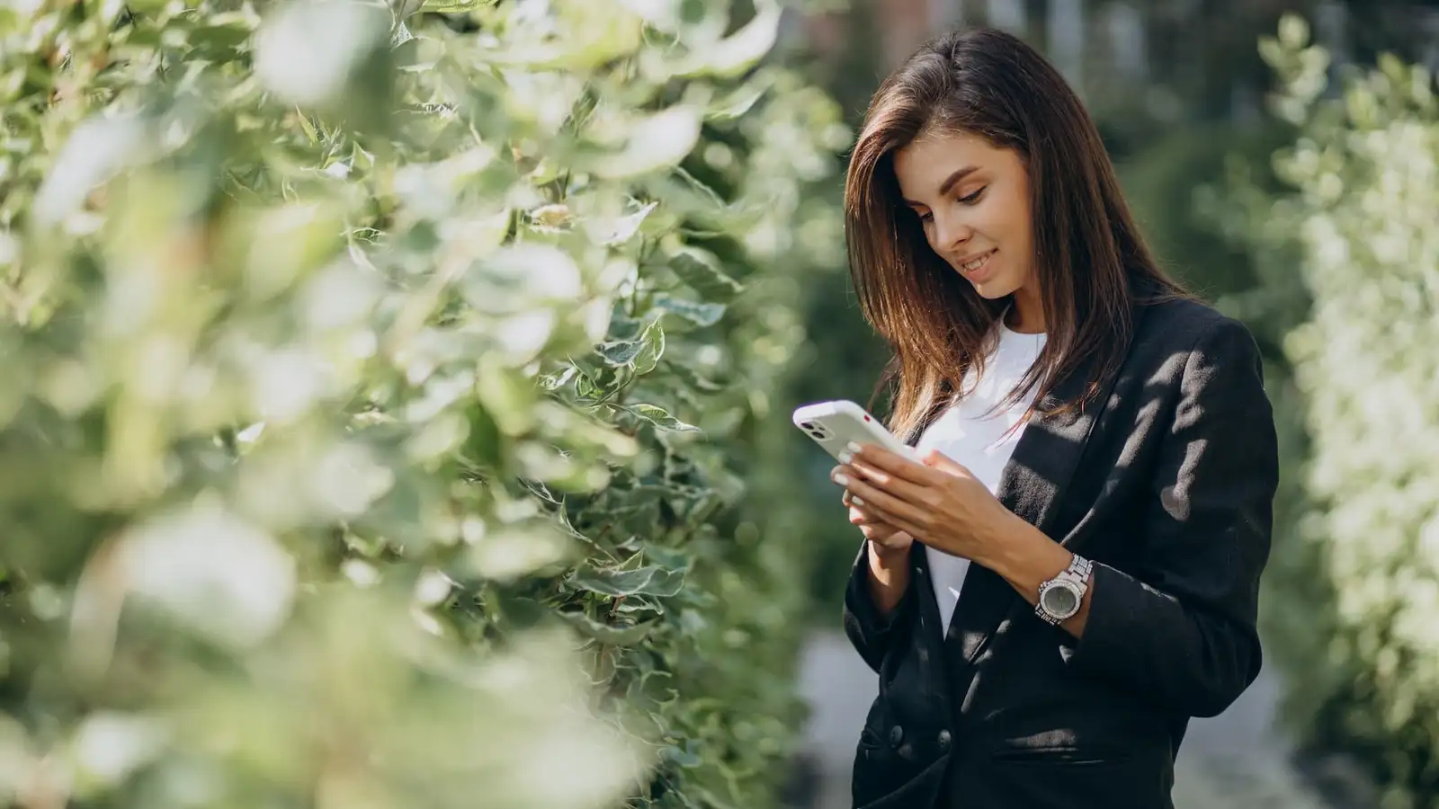 donna con cellulare in mano in un parco-1.jpg