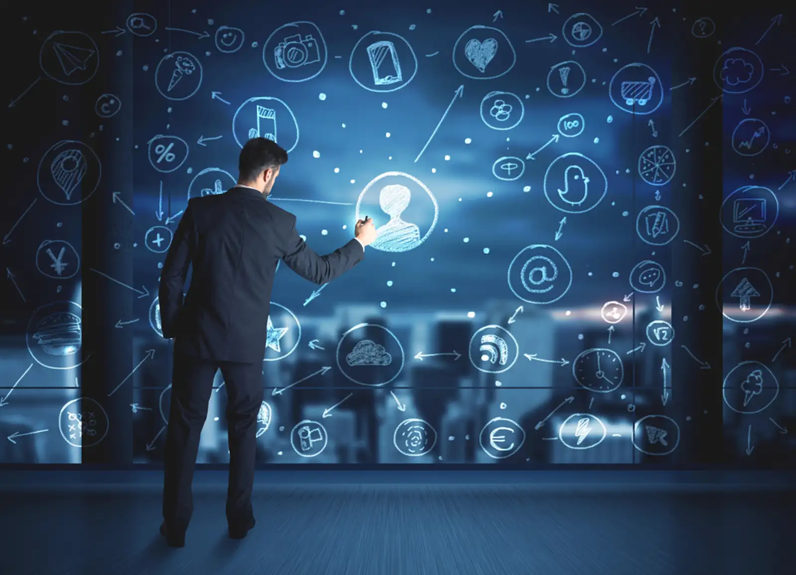 Businessman drawing social media connection scheme on glass window with night cityscape background.jpeg