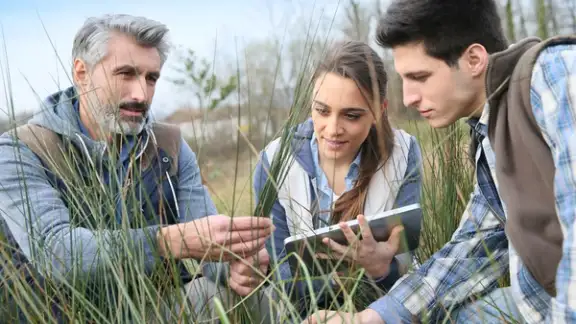 Teacher with students in agronomy looking at vegetation.jpeg