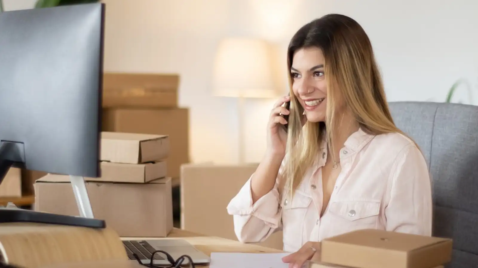 ragazza con il cellulare in mano al pc con scatole dietro-1.jpg