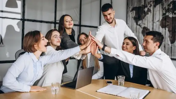 gruppo di persone lavora in ufficio battendosi la mano.jpg