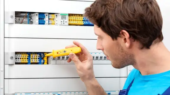 Repairman checking a voltage and fixing a switchboard.jpeg