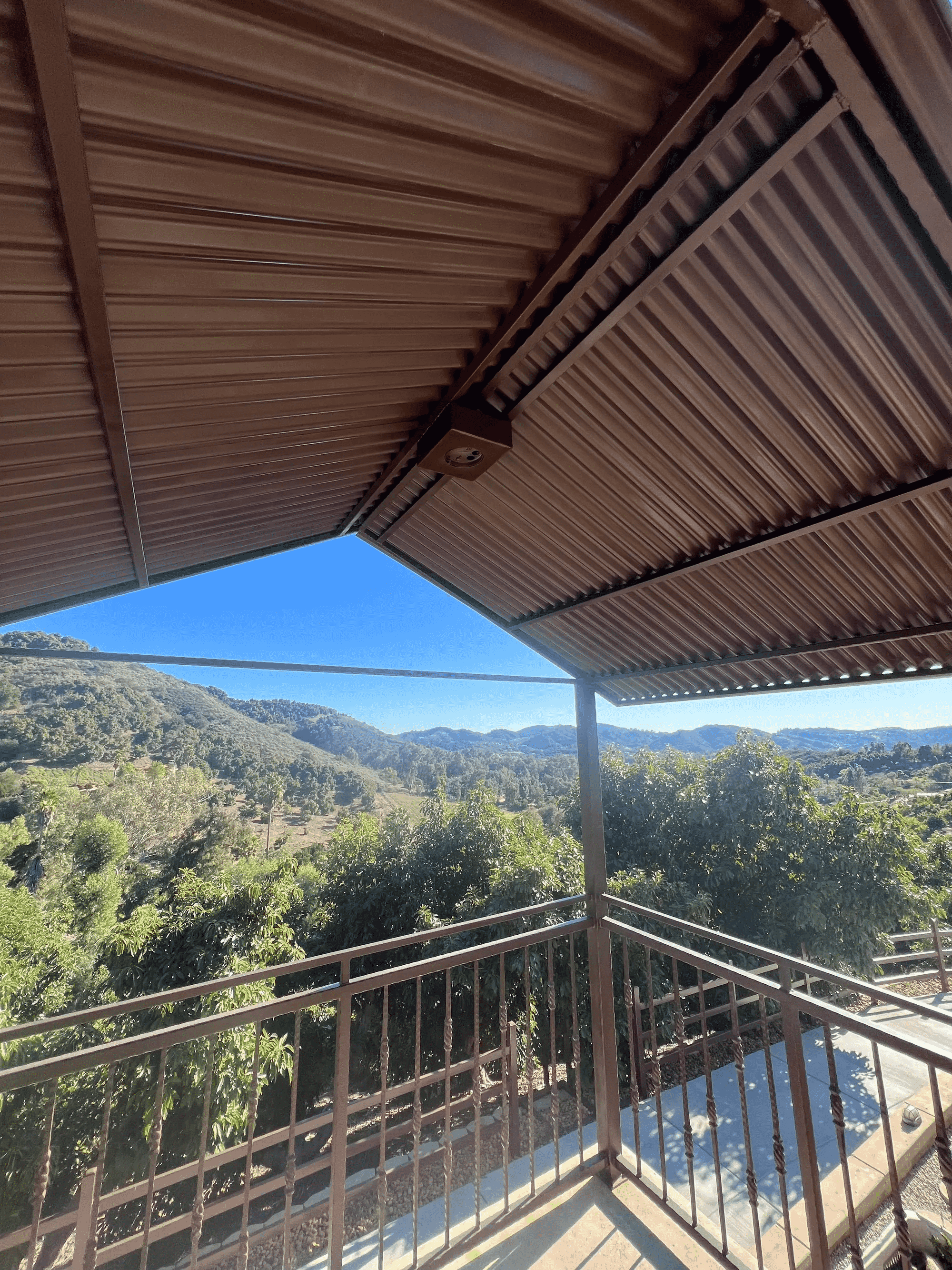 Custom welded pergola overlooking driveway entrance 