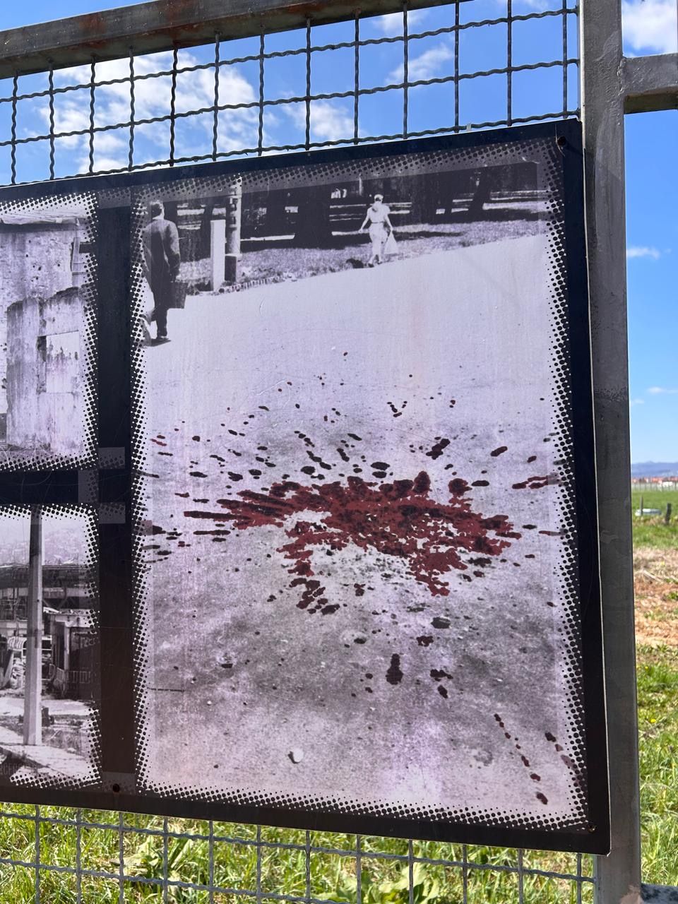 Historical photo displayed at the Sarajevo Tunnel Museum, showing a blood stain on the pavement