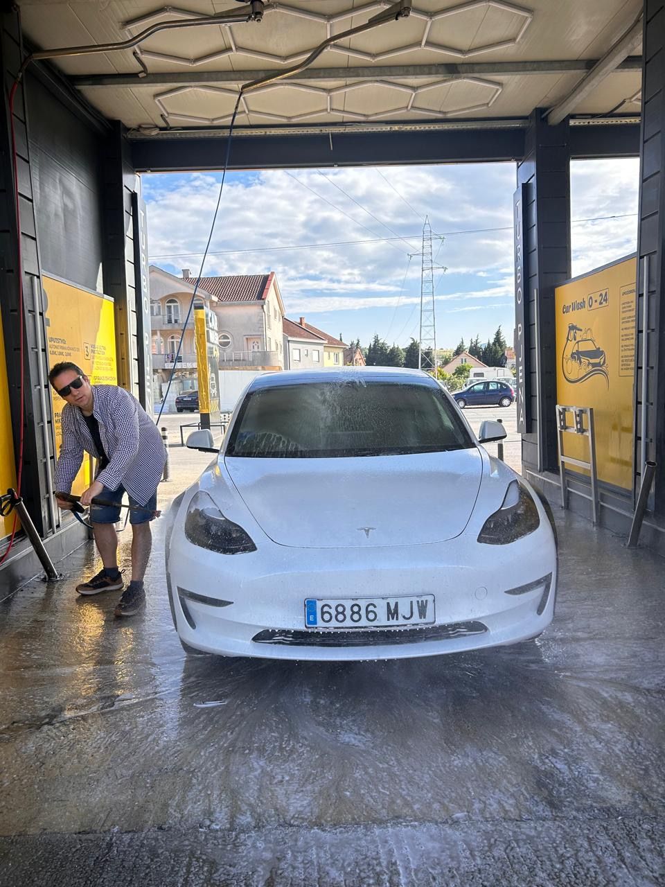 Gonzalo washing the Tesla at a car wash in Podgorica