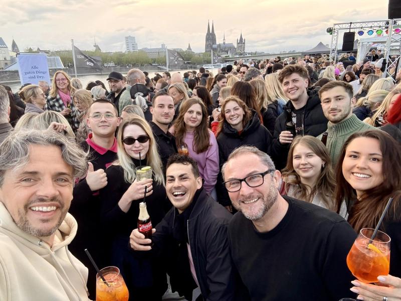 Grosses Team-Selfie beim Sommerfest mit Koelner Dom im Hintergrund