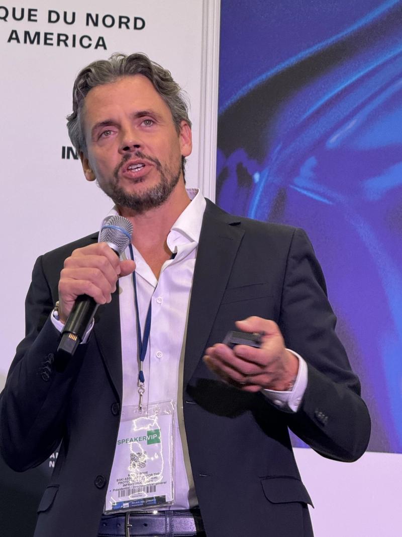 Manuel Bohe spricht mit Mikrofon auf einer Buehne