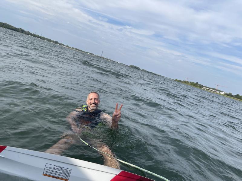 Kollege schwimmt laechelnd im See