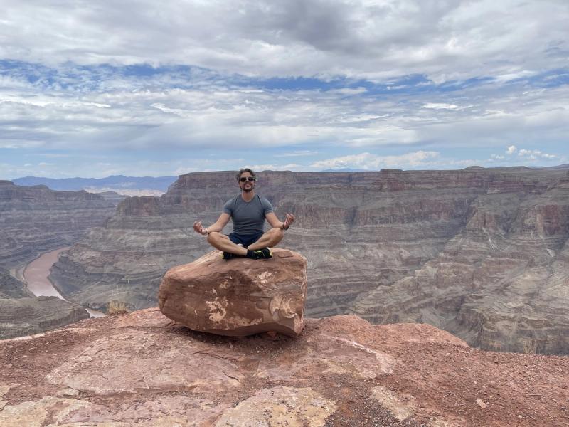 Person meditiert auf einem Felsen am Grand Canyon