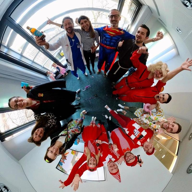 Team in carnival costumes forming a circle and looking into the camera