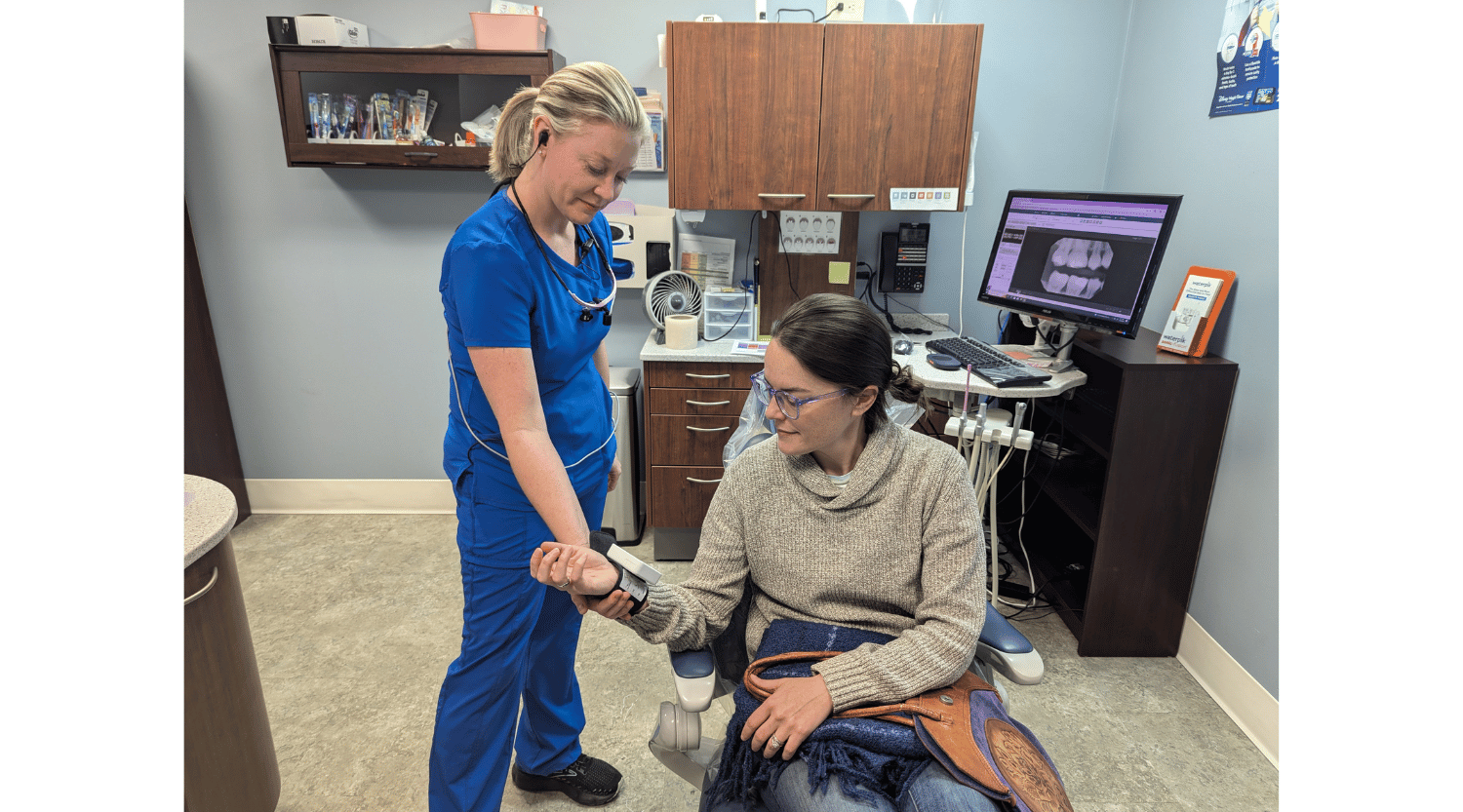 Registered dental hygienist Melissa Alderman checks a patient's blood pressure during a routine checkup.