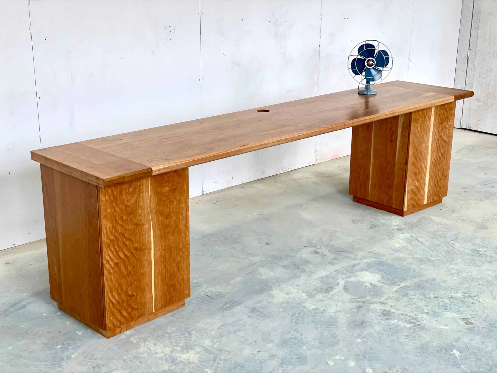 A long solid cherry pedestal desk