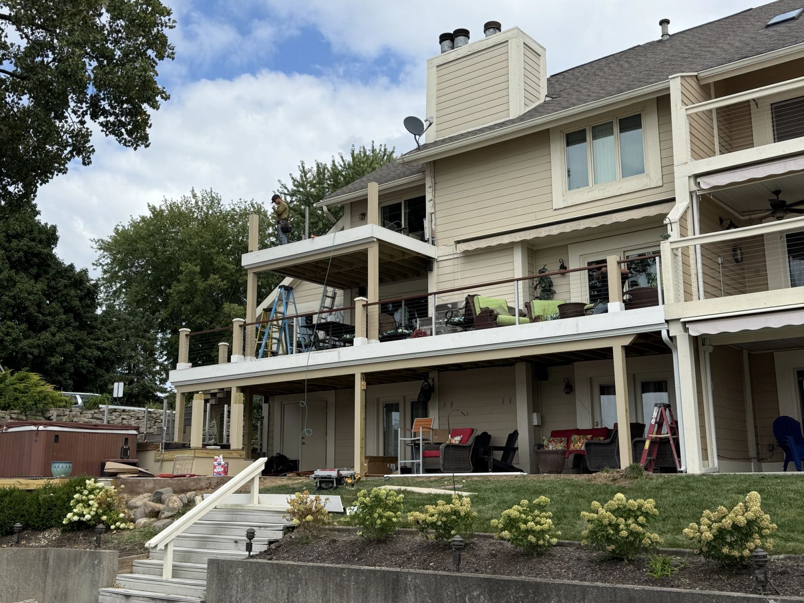 Completed two-story composite deck with white pergola and cable railing in Fishers Indiana