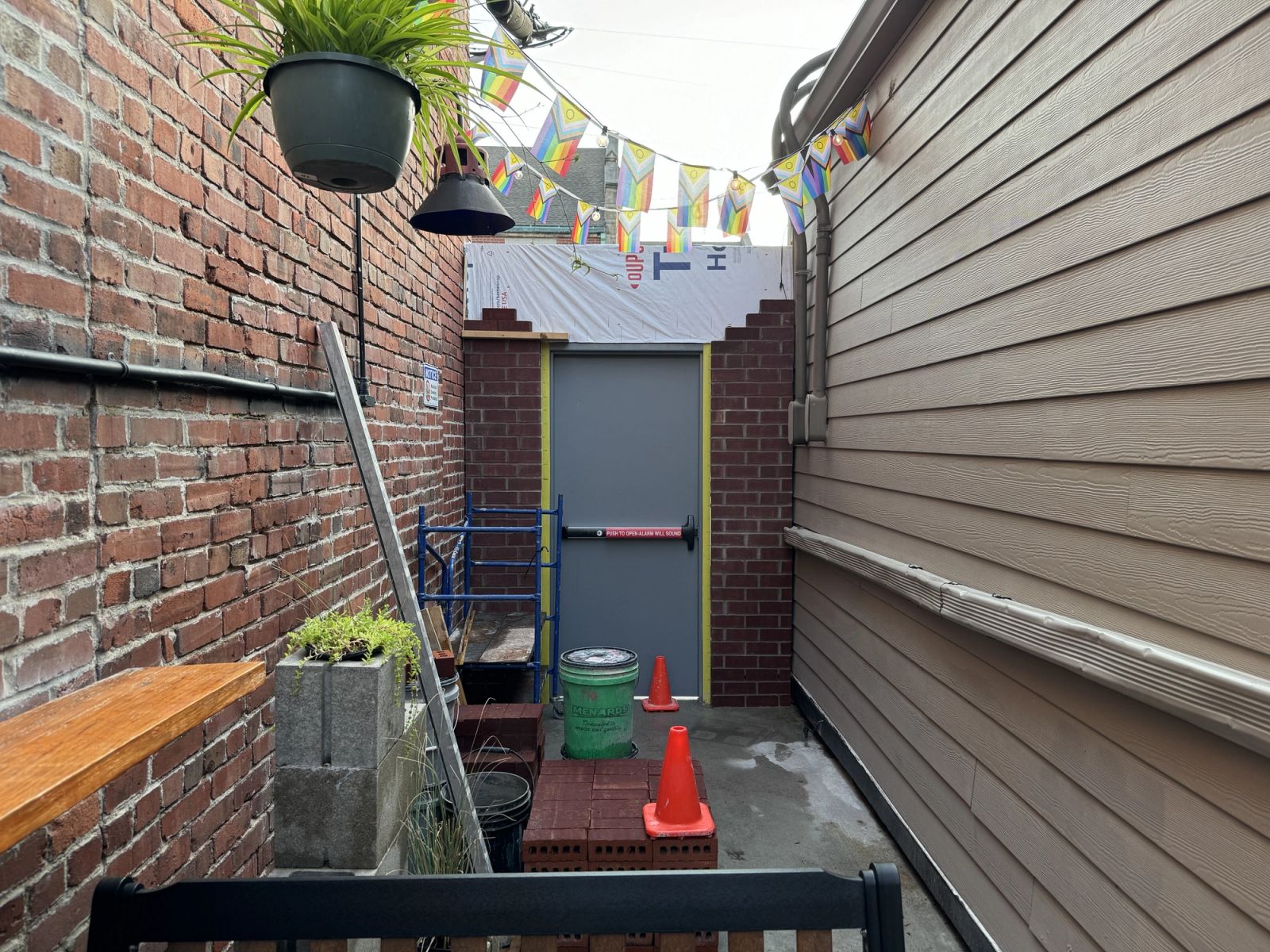 Completed custom brick storage structure in Indianapolis alley with steel door