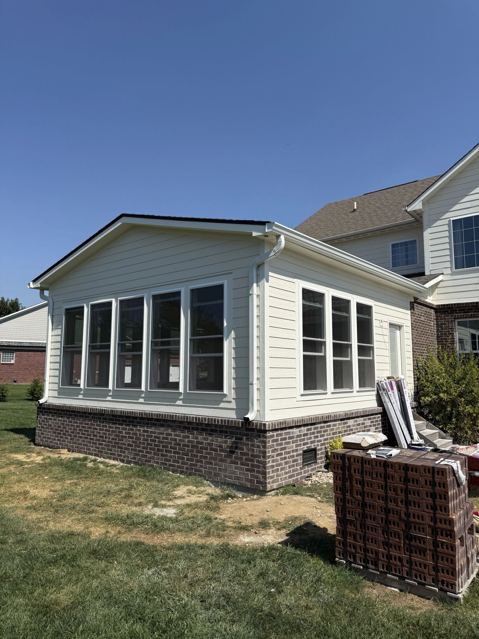 Completed sunroom addition in Avon Indiana with brick foundation and large windows