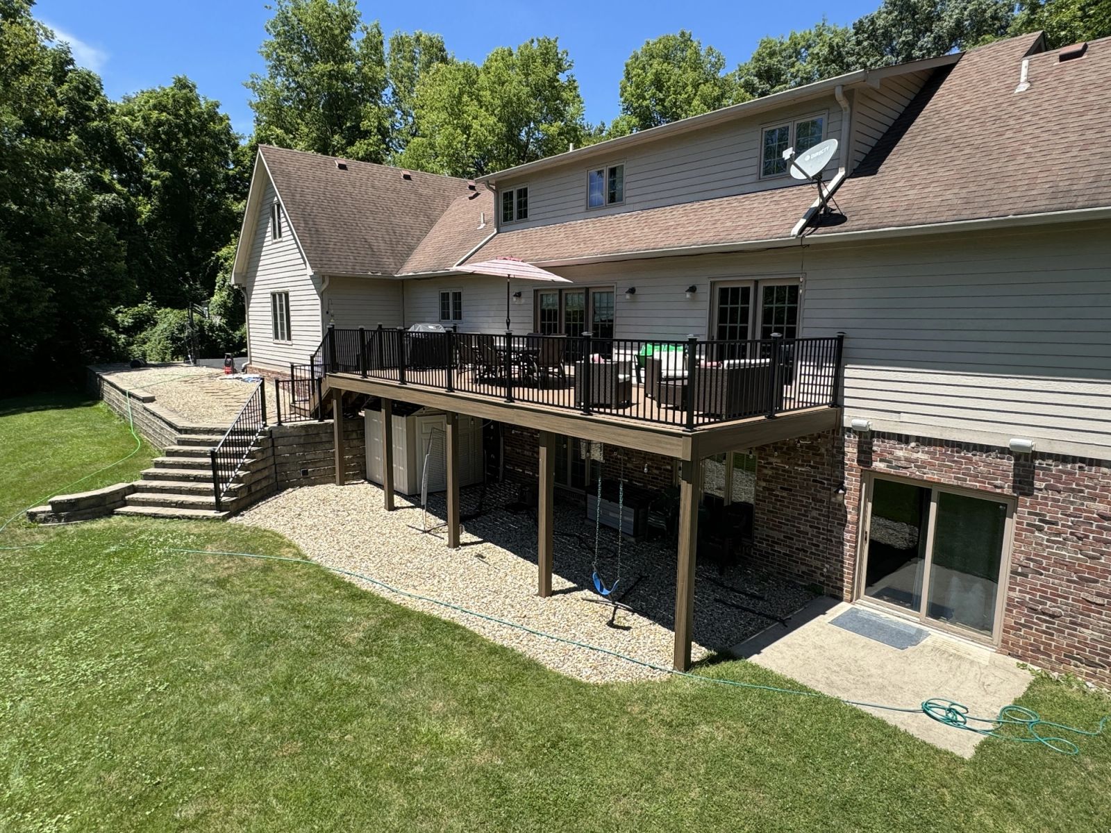 Elevated deck with aluminum railing and covered gravel patio near Geist Reservoir Indianapolis