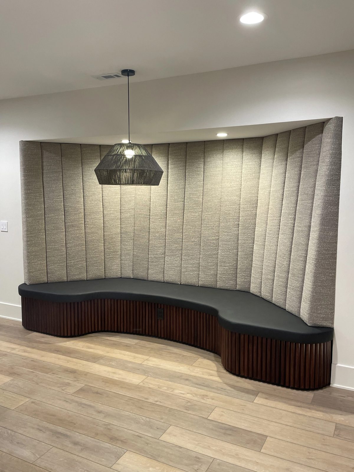 Custom curved banquette with walnut base and upholstered wall panels in Broad Ripple Indianapolis