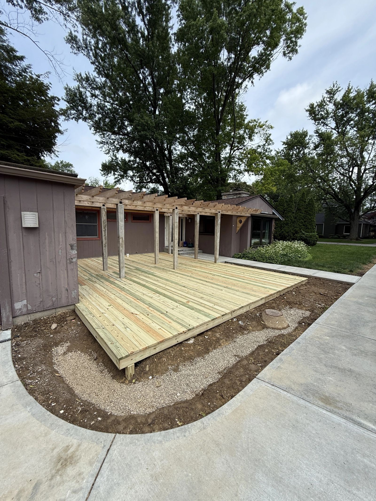 Anderson residential front yard renovation with pressure-treated deck and concrete walkways