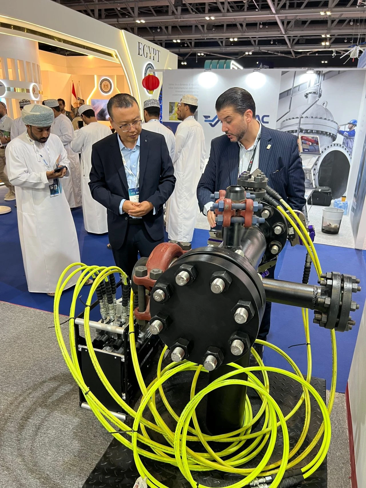people looking at demo flange with bolts and hoses at hytorc booth at Oman Petroleum & Energy Show  opes in muscat oman