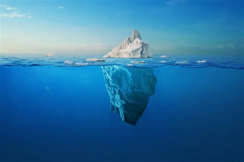 iceberg floats on blue water