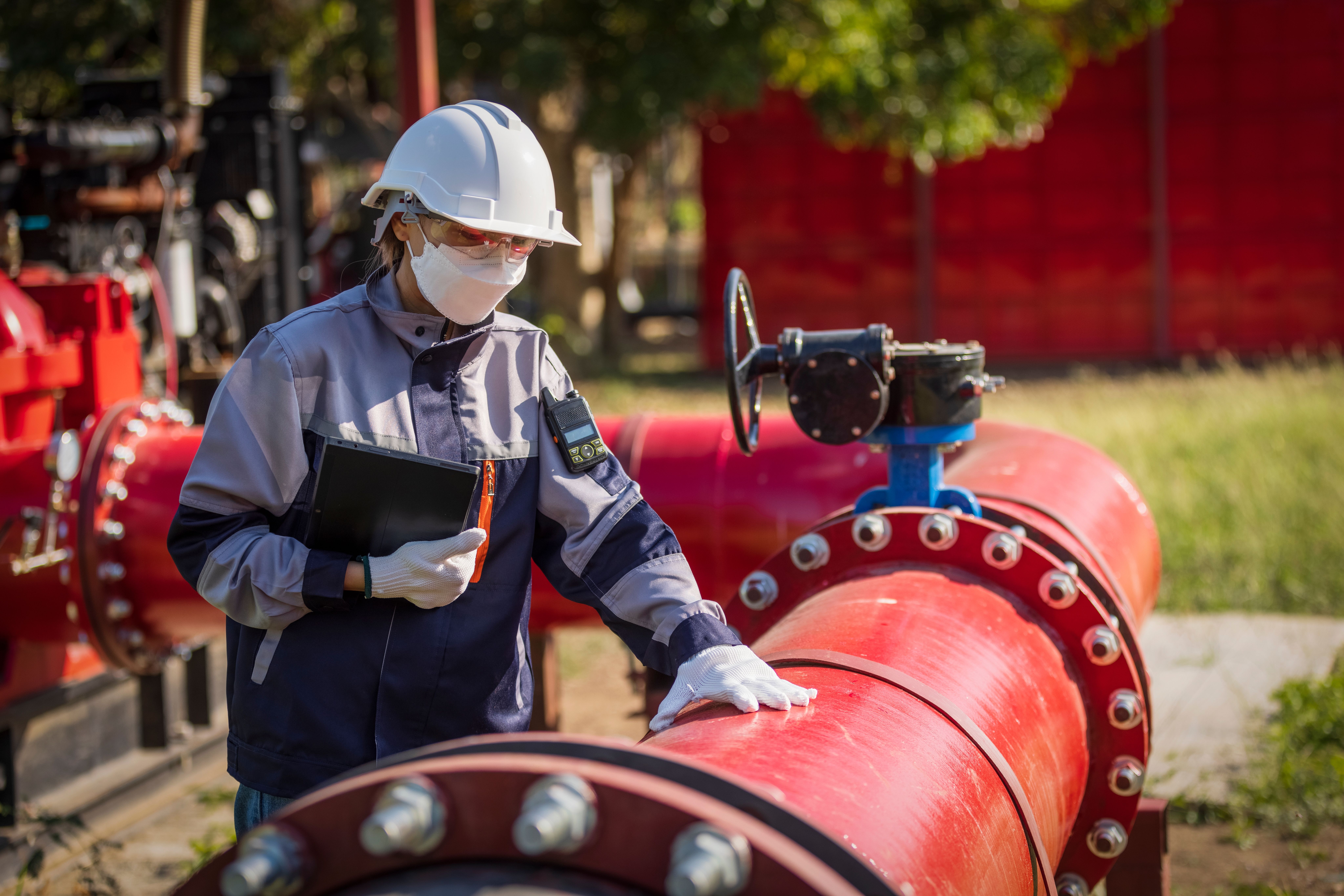 Asian female worker working on pipeline with flanges