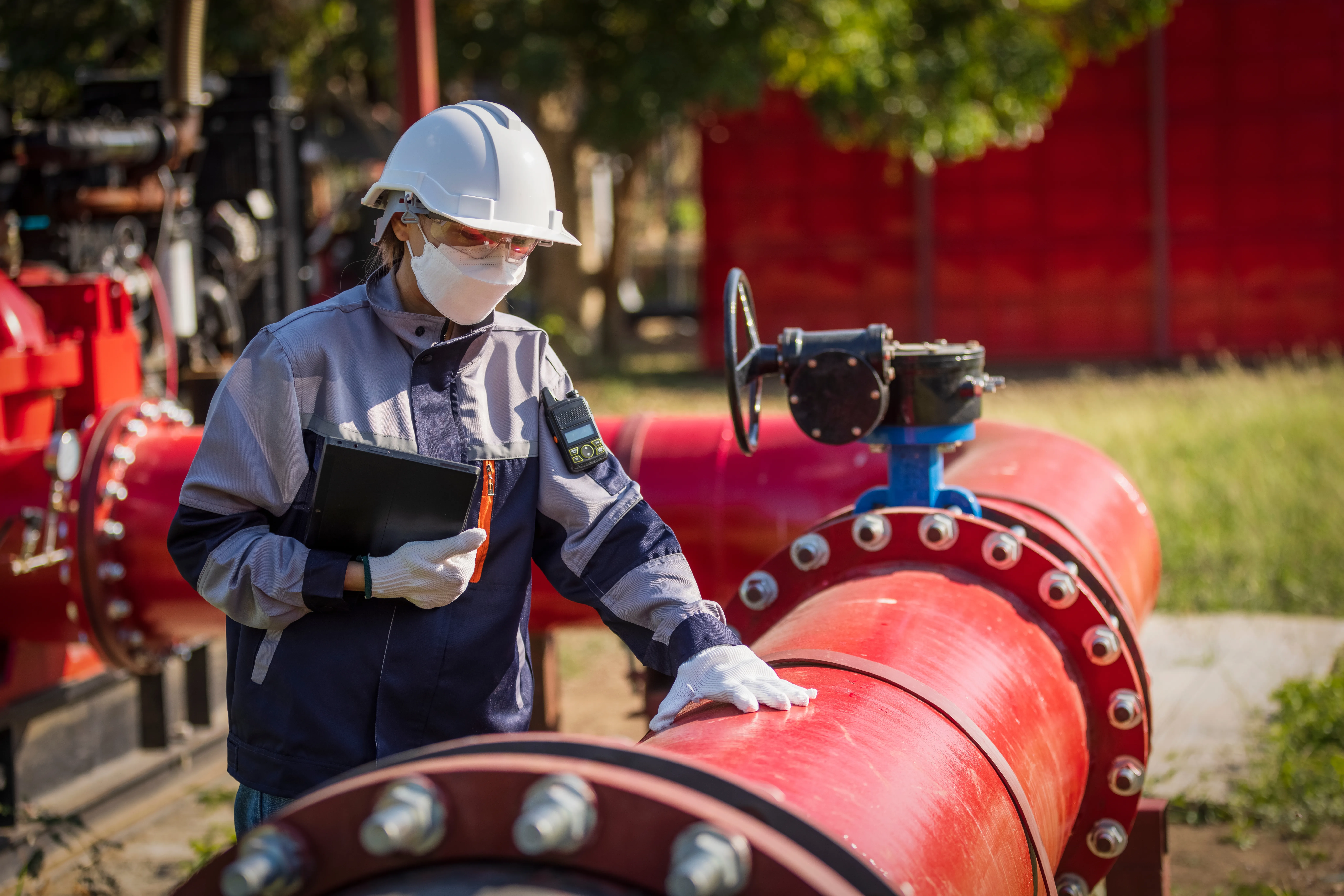 Asian female worker working on pipeline with flanges