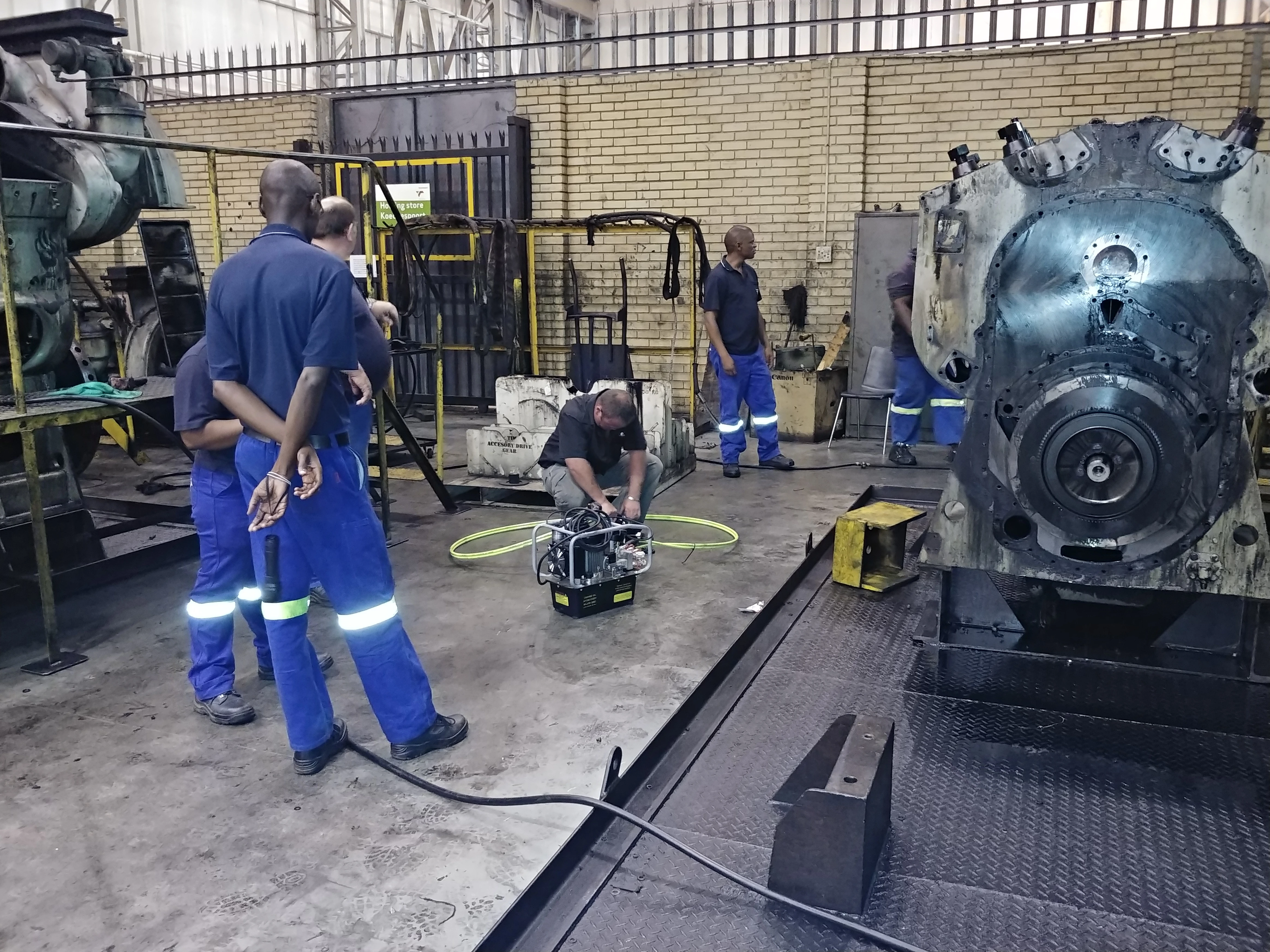 EMD locomotive with hytorc pump and tools people working