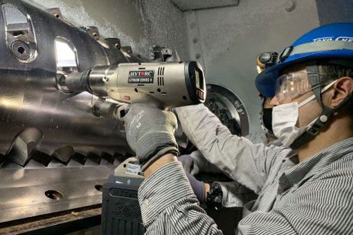 person using hytorc lst to bolt wearing PPE