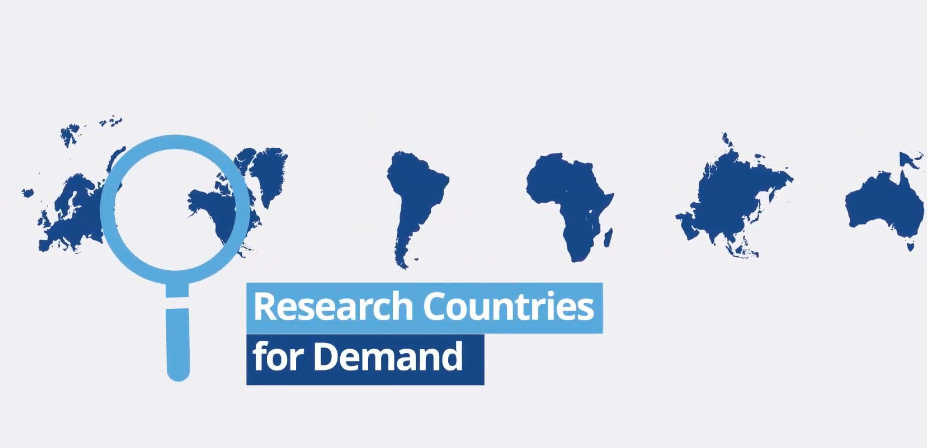Magnifying glass over a world map: researching global market demand for a manufacturing marketing strategy.