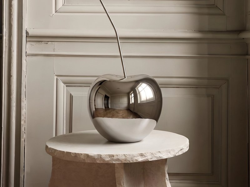 The oversized cherry silhouette is cast in one continuous flowing form, finished in a flawless mirror-chrome plating.