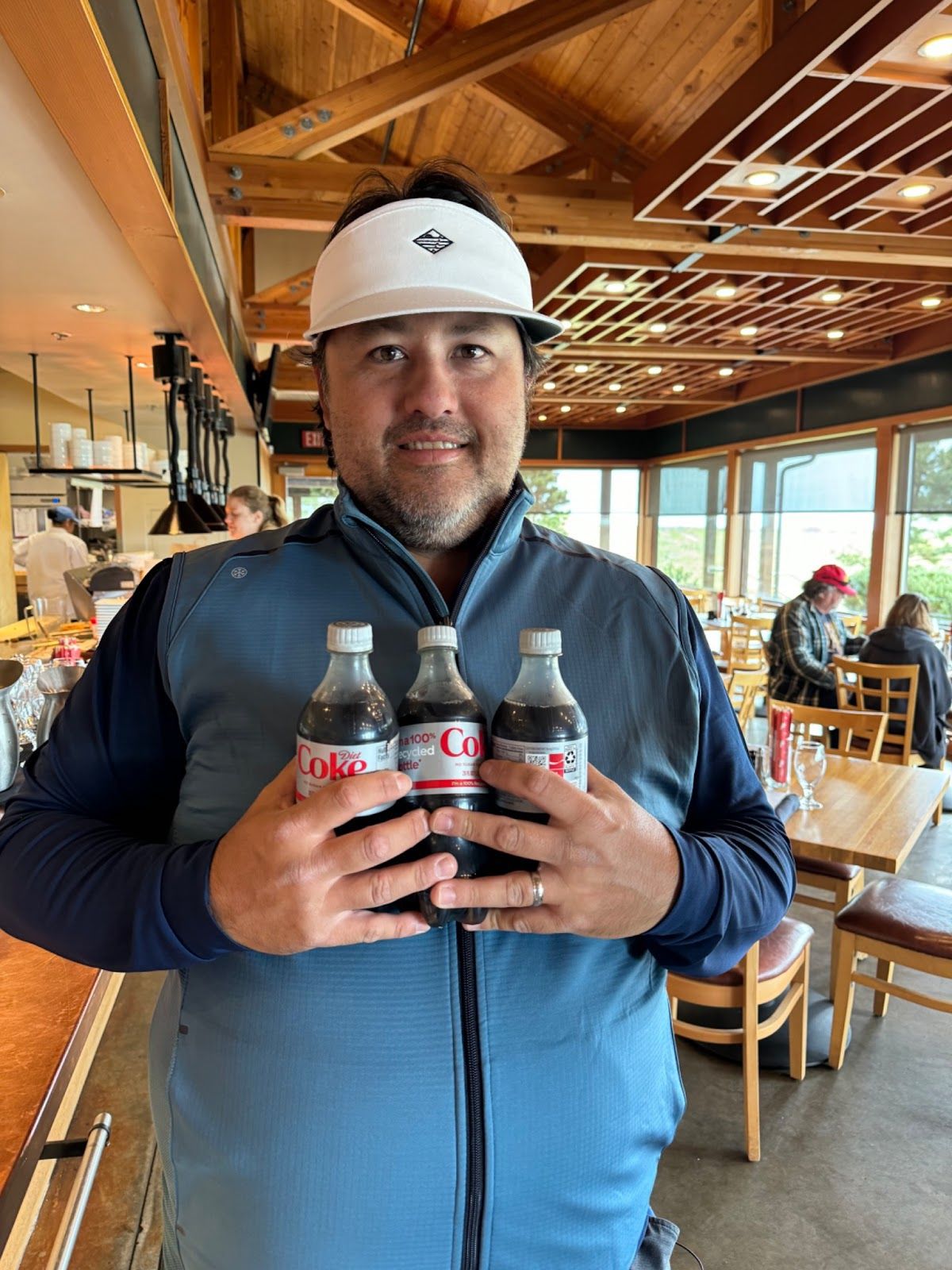 Poosh excitedly holds up three bottles of Diet Coke.