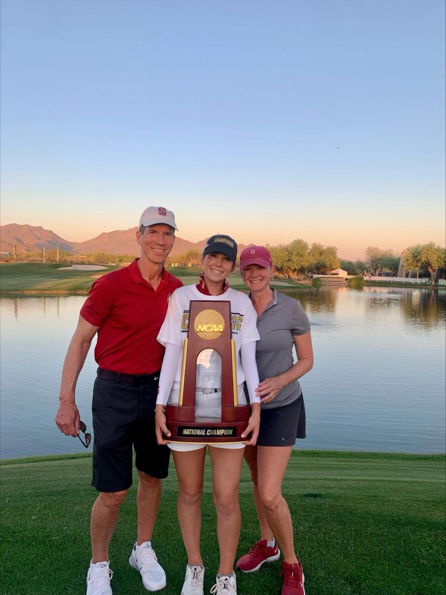 Rachel Heck and her parents pose with the NCAA women's golf championship trophy.