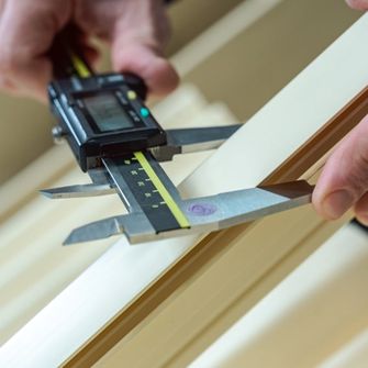 Gros plans sur des mains tenant un outil de mesure de l’épaisseur