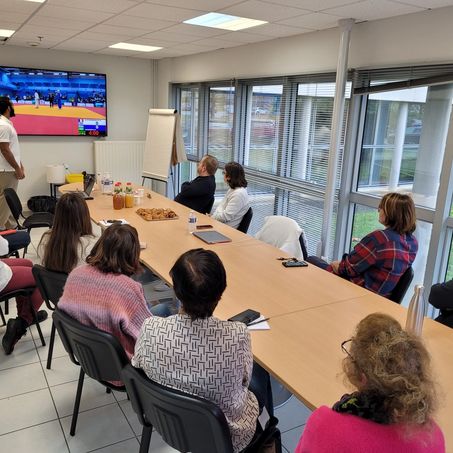 L'athlète Hélios présentant son parcours aux collaborateurs de Seifel assis autour d'une table