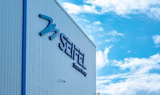 Logo de Seifel sur la façade de l'usine avec un ciel bleu et quelques nuages