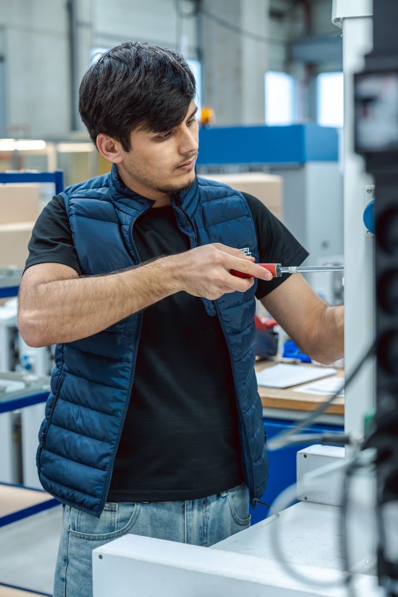 Jeune homme travaillant avec un outil type tournevis