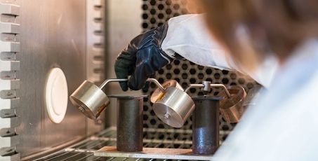 Main portant un accessoire à l’intérieur d’une chambre climatique pour préparer un test produit en laboratoire