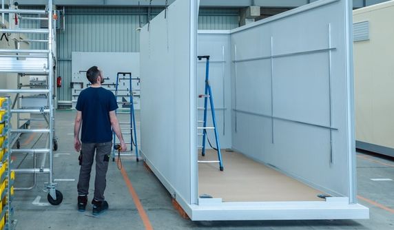 Homme regardant un shelter en cours de fabrication
