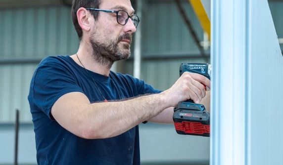 Homme travaillant avec un outil sur un pan de shelter