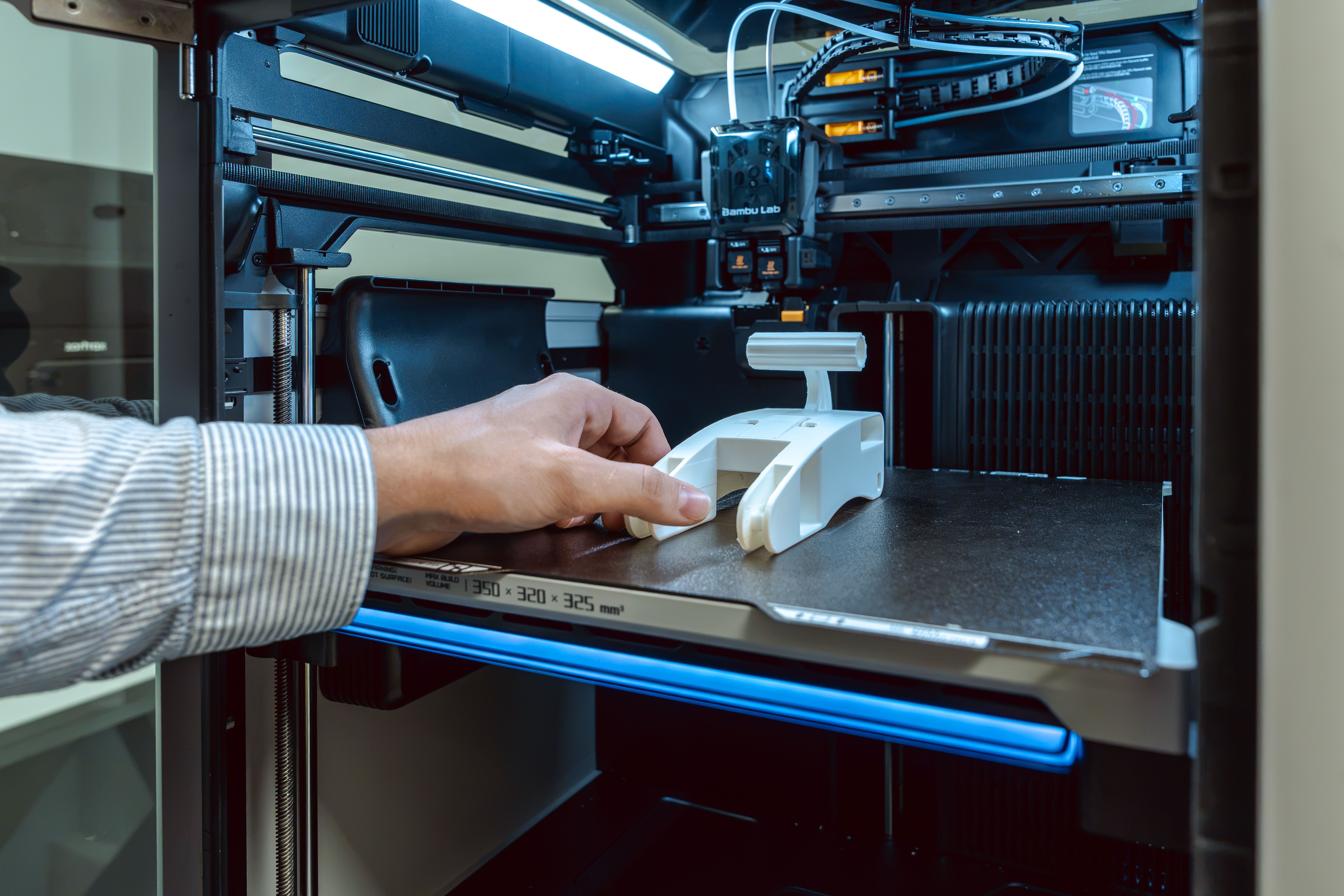 Main tenant un prototype venant d’être fabriqué par une imprimante 3D