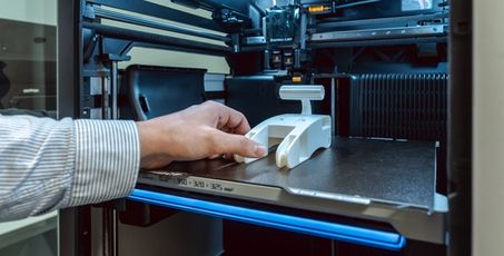 Main tenant un prototype venant d’être fabriqué par une imprimante 3D