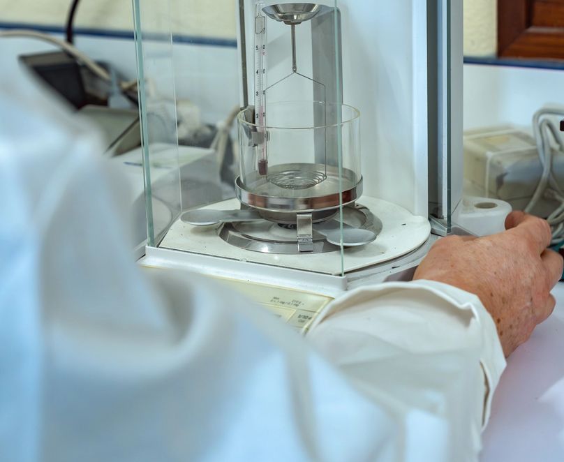 Main en train de manipuler une machine dans le laboratoire matière de Seifel