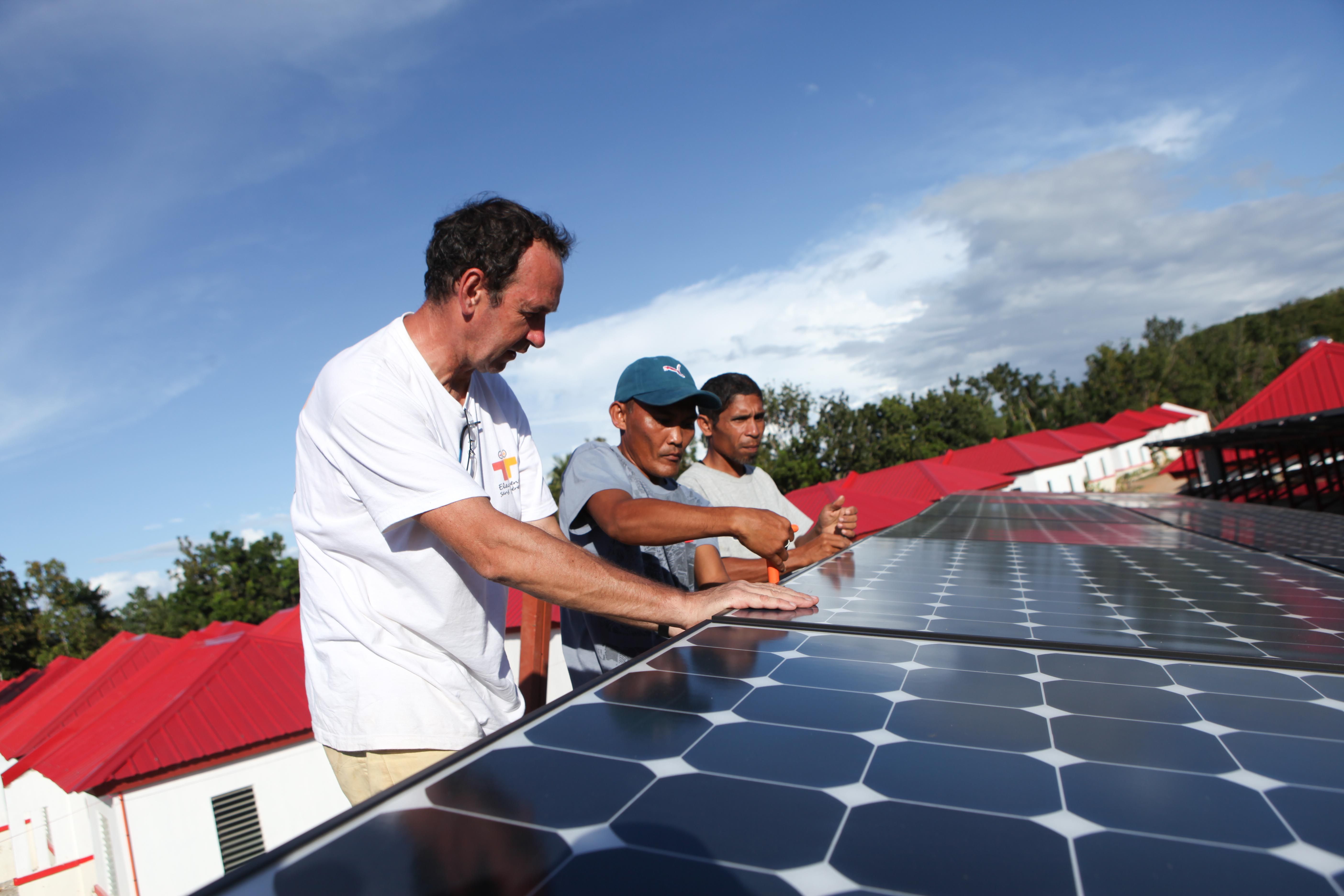 Trois personnes travaillant sur des panneaux solaires