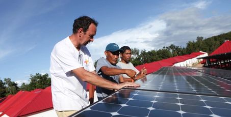 Trois personnes travaillant sur des panneaux solaires