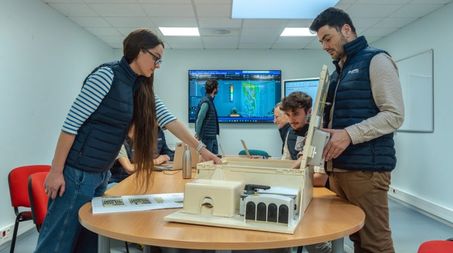 Equipes R&D réunies dans une salle autour d’une table avec un abri coffret électrique