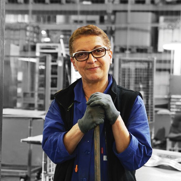 Collaboratrice du Groupe Sicame portant des gants de sécurité et souriant à la caméra