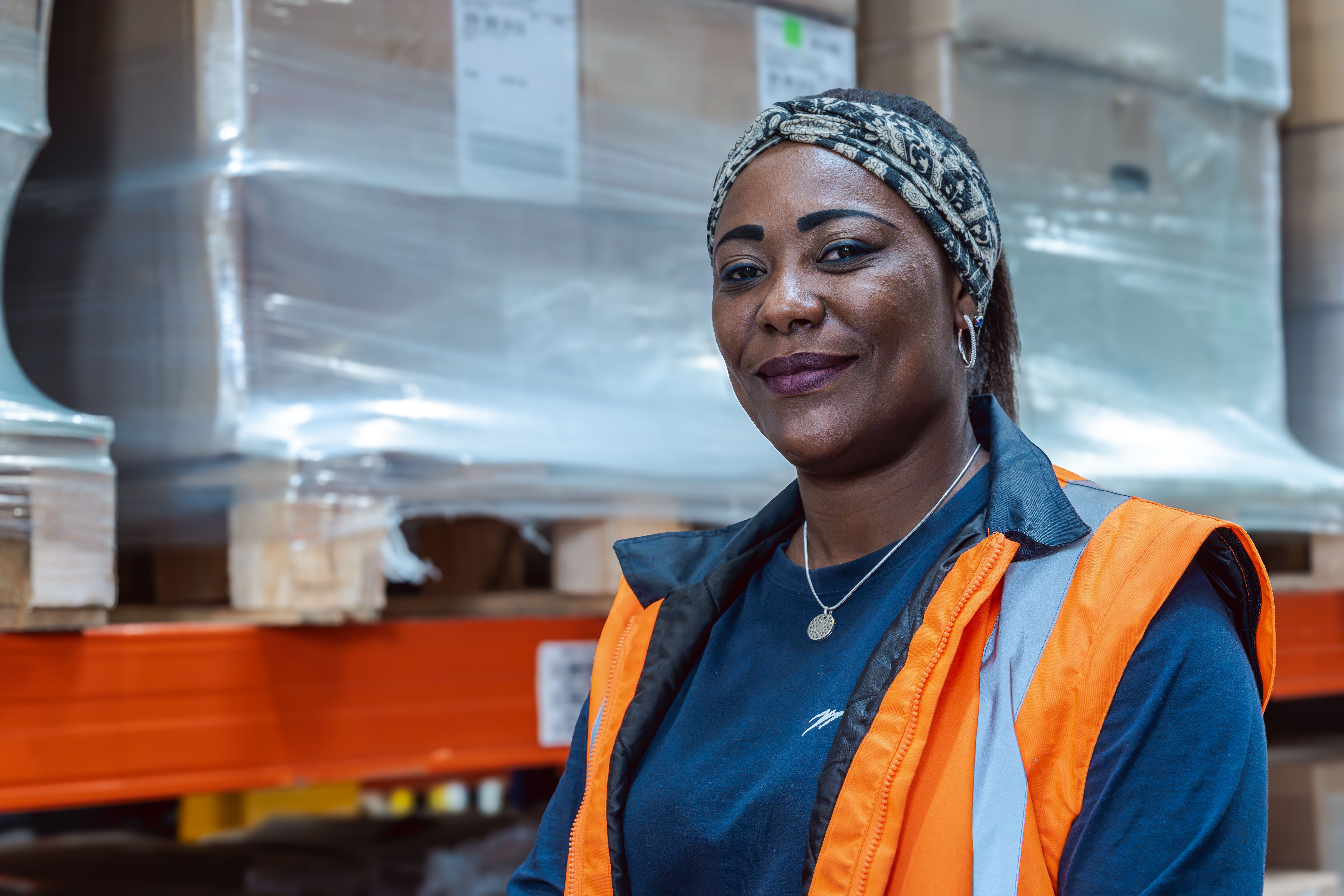 Collaboratrice souriante et portant une veste de sécurité
