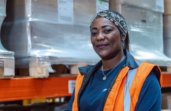 Collaboratrice souriante et portant une veste de sécurité